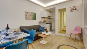 Un espace de vie compact comprenant un coin repas, une kitchenette et une petite salle de bain.