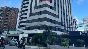 A tall, modern building with a distinctive red vertical stripe. - Beautiful and cozy flat. Complete and just 50 m from the beach  (Candeias Jaboatão dos Guararapes)