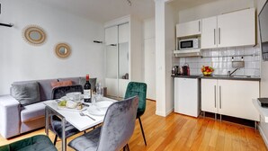 A modern apartment with a dining area, a kitchen, and a living room. - 316 Suite BIOT 5 - Superb apartment in Paris (Paris 17 Batignolles-Monceau)