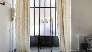 Quarto com janela, varal e radiador.