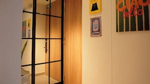 Ein Zimmer mit einer Schiebetür, einem Wandventilator und einem gerahmten Bild.