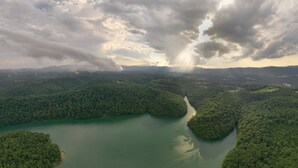 Vista aérea de un río serpenteando por una zona boscosa densa bajo un cielo nublado.
