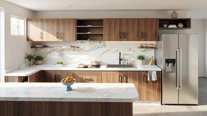 Una cocina moderna con armarios de madera, encimera de mármol, pileta integrada y refrigerador de acero inoxidable.
