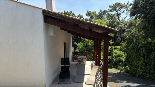 A covered outdoor area with a grill and seating.