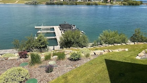 A lakeside property with a dock, grassy areas, and a small building. - New! 3-bedroom lake-front condo on Flathead Lake (Polson)