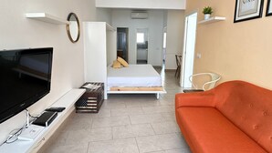 A modern, well-lit room with a bed, a television, and a sofa. - Joan Badosa 1 A in Roses (Roses)