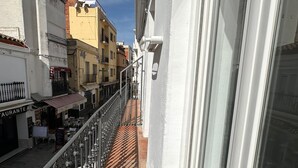 A narrow balcony with a metal railing overlooking a street with buildings and a restaurant. - Joan Badosa 1 A in Roses (Roses)