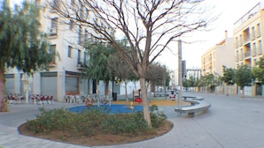 A courtyard with a central tree, benches, and a circular seating area. - Cosconilles Bajo in Roses (Roses)