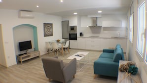 A modern living room with a sofa, TV, and dining area. - Cosconilles Bajo in Roses (Roses)