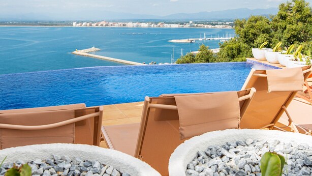 An infinity pool with a view of the sea and distant cityscape. - Castell Mar 1001 in Roses (Roses)