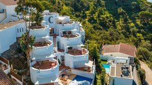 A modern villa with multiple circular balconies, a swimming pool, and a view of a historic castle. - Castell Mar 1001 in Roses (Roses)