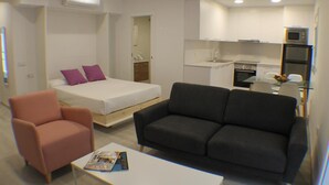 A compact living space with a bed, a sofa, a small table, and a kitchenette. - Cosconilles 1 in Roses (Roses)