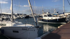 Una marina con diverse imbarcazioni ormeggiate, tra cui una barca bianca con la scritta "itaca".