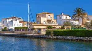 A coastal town with white buildings, a palm tree, and a clear blue sky. - Marina 9 in Roses With 1 Bedrooms and 1 Bathrooms (Roses)