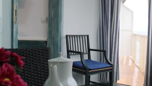 A room with a chair, a tray with a teapot, a bowl, and a vase with flowers. - Avenida 5C in Roses With 2 Bedrooms and 2 Bathrooms (Roses)