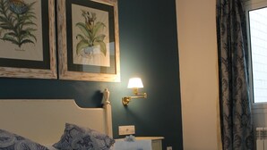 A neatly made bed with blue patterned pillows, a folded towel, and a wall-mounted lamp. - Avenida 5C in Roses With 2 Bedrooms and 2 Bathrooms (Roses)
