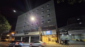 Un immeuble à plusieurs étages, sur lequel on peut lire les enseignes « BRAD CITY » et « Hôtel Kalunga ».