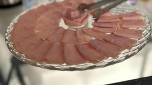 Un plat en verre sur lequel des tranches de viande sont disposées en cercle.