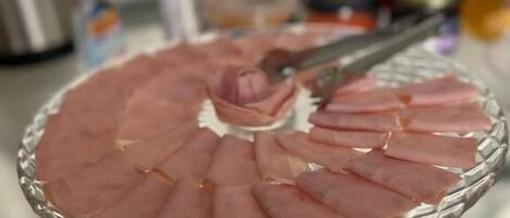 A glass platter with sliced meat arranged in a circular pattern.