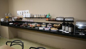 Un comptoir de buffet proposant divers plats, des condiments et une machine à café.