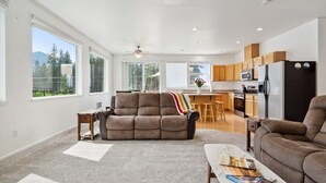 Amplia sala de estar con sofá, mesa de centro y vistas a una cocina y comedor.