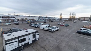 A parking lot with various vehicles, including cars, trucks, and a trailer. - Home Away From Home (Prince George)