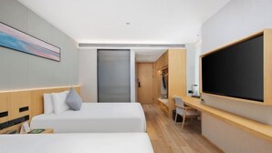 A modern hotel room with two beds, a desk, a television, and a sliding door closet. - Tianping Hotel Shanghai Xujiahui（Wukang Road） (Shanghai)
