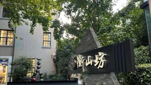 A building entrance with a sign in Chinese characters, surrounded by greenery and a decorative sculpture. - Tianping Hotel Shanghai Xujiahui（Wukang Road） (Shanghai)