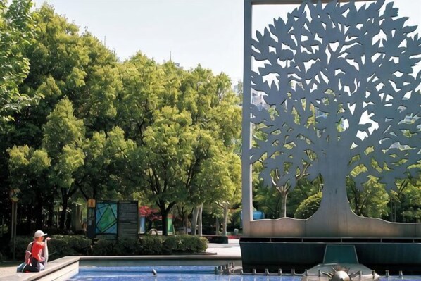 A tree sculpture, a fountain, and a person in a red shirt. - Tianping Hotel Shanghai Xujiahui（Wukang Road） (Shanghai)