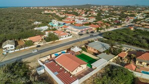 Residential homes with red-tiled roofs are surrounded by lush greenery in this suburban neighborhood.