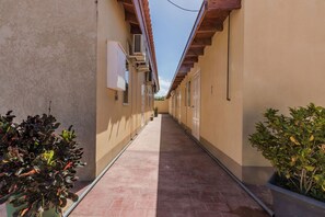 Stroll through the serene corridor lined with lush greenery and picturesque buildings.
