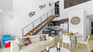 A modern apartment with a living room, dining area, kitchen, and a staircase. - 2BR 2BA Duplex w Amazing Views Pool Amenities (Noord)