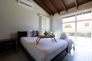 Une chambre à coucher avec un lit, une table de chevet et une fenêtre donnant sur l’extérieur.