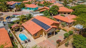 Zona residencial con casas de techos rojos y paneles solares.