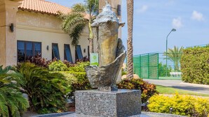 Un patio con una fuente, palmeras y un edificio con techo de tejas.
