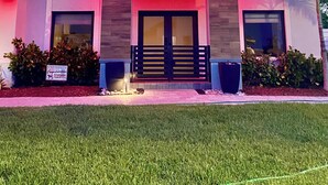 A modern two-story house with a flat roof, large windows, and a well-maintained lawn. - Tropical Oasis (Quail heights)