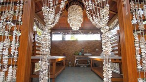 A room with wooden furniture, a chandelier, and a window with a view. - Hotel Coral Beach  (Tamandaré)