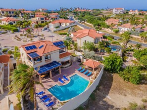 A resort with a swimming pool, multiple buildings, and solar panels.