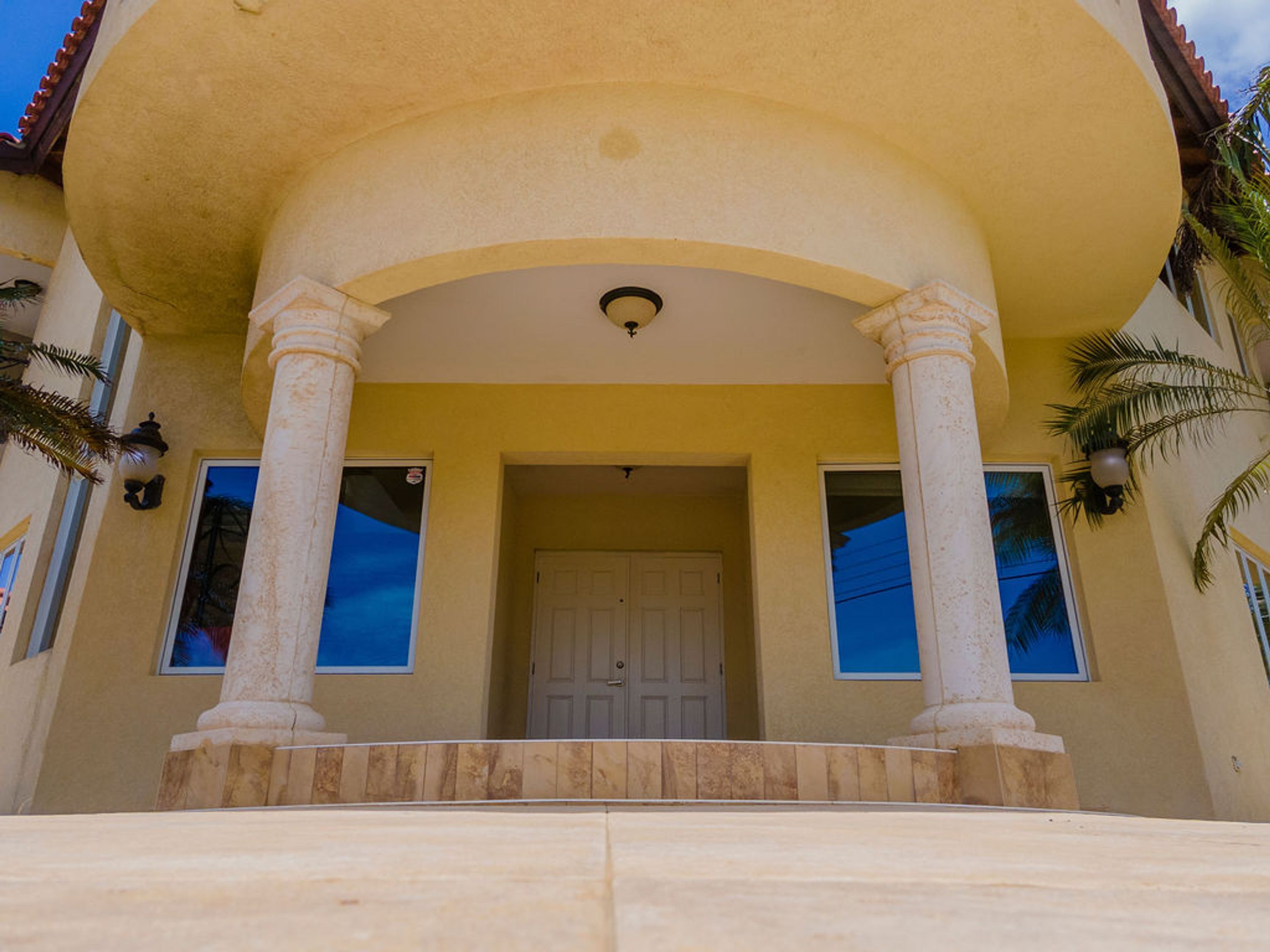A building with a large entrance, two columns, and a door.