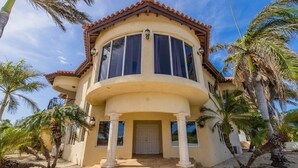 A two-story house with a curved balcony, large windows, and a front door. - Amazing 4br4ba Villa w Pool Birdsanctuary Views (Noord)