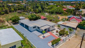 A modern house with a flat roof, a covered patio, and a view of a coastal town. - Lovely 3br2ba w Wifi Parking in Central Location (Paradera)