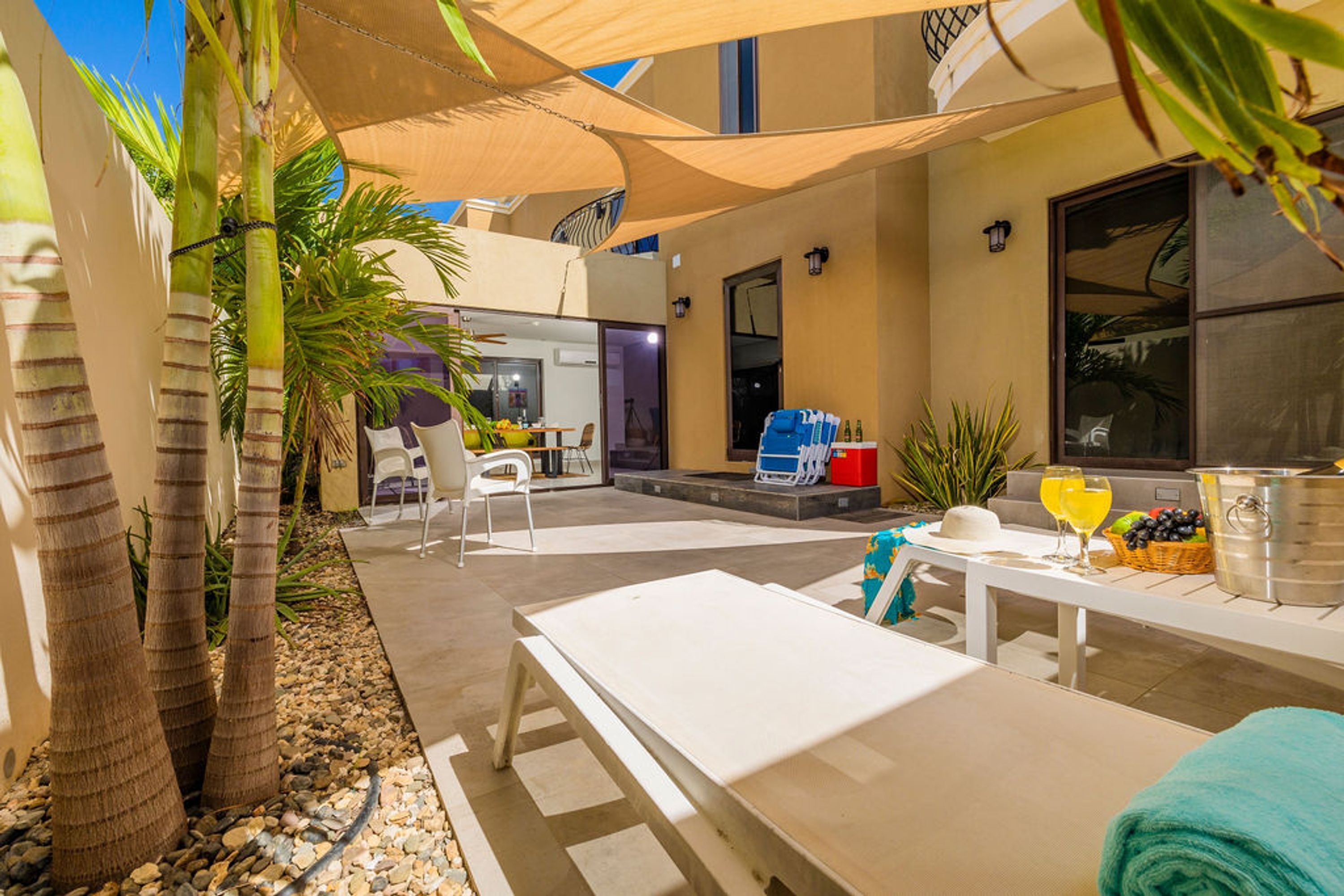 Eine Terrassenanlage im Freien mit einem weißen Tisch, Stühlen und einem Grillbereich.