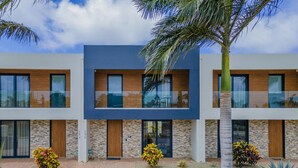 A modern two-story building with a brick pathway leading to the entrance. - Serene Designer Gem Walk to Beach Strip Pool (Noord)