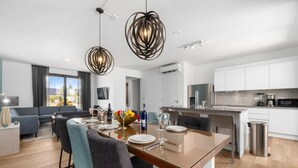 A modern kitchen with white cabinets, a stainless steel sink, and a microwave. - Serene Designer Gem Walk to Beach Strip Pool (Noord)
