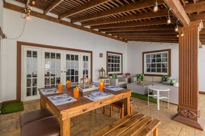 A dining area with a wooden table set for four, surrounded by a cozy seating arrangement. - Remodeled 3br2ba Cozy Central Private Pool (Paradera)