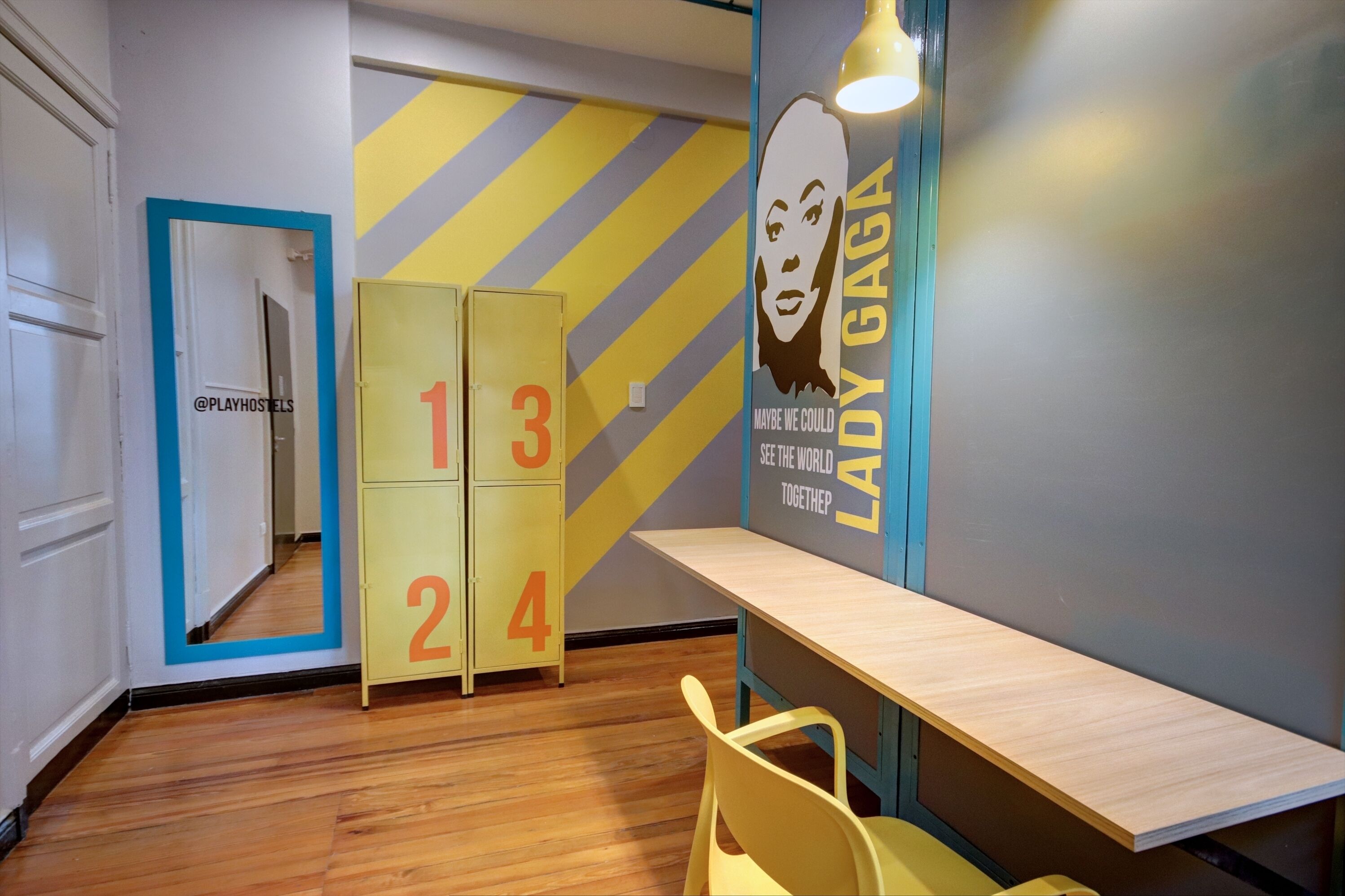 A hallway with a mirrored wall, a number display, and a poster of Lady Gaga.