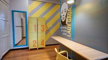 A hallway with a mirrored wall, a number display, and a poster of Lady Gaga.