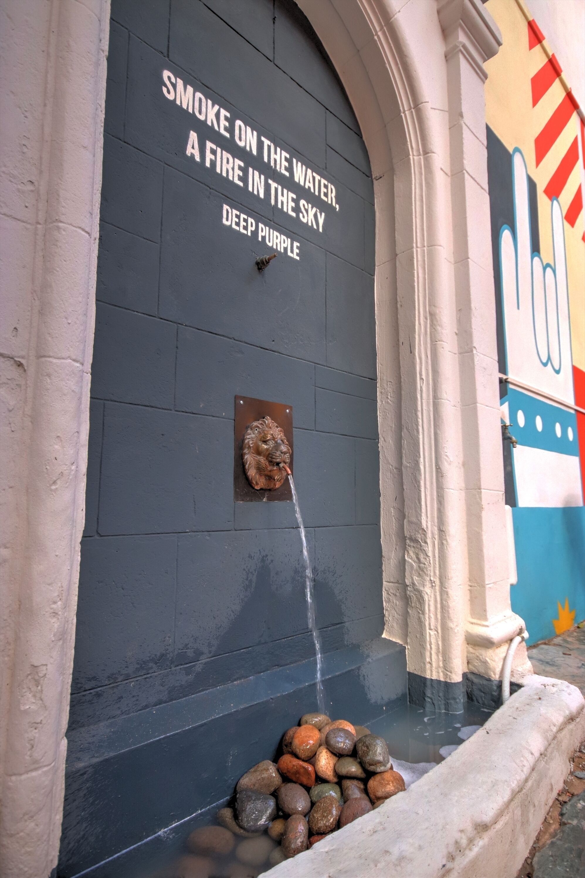 A wall with the text "Smoke on the water, a fire in the sky, deep purple."