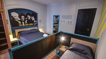 Un dormitorio con una litera, un cartel de The Rolling Stones, un cartel con texto relacionado con la música y una puerta con cerradura.