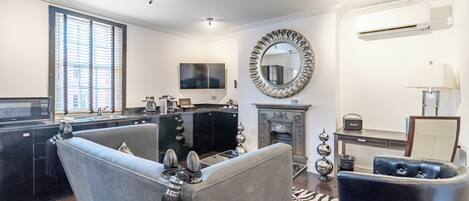 A modern living room with a fireplace, a television, and a dining area.